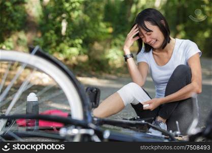 scared woman crying near crashed bike