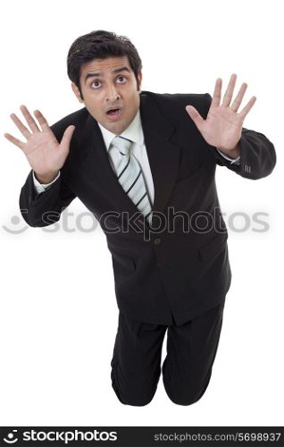 Scared young businessman protecting himself from something