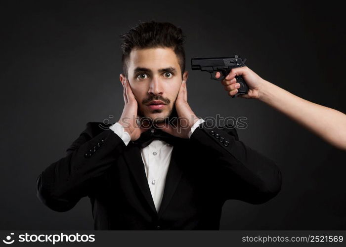 Scared young man with a weapon against his head