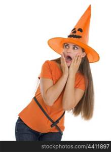 Scared young woman in Halloween hat looking on copy space