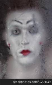 Scary face screaming mime for murky glass closeup