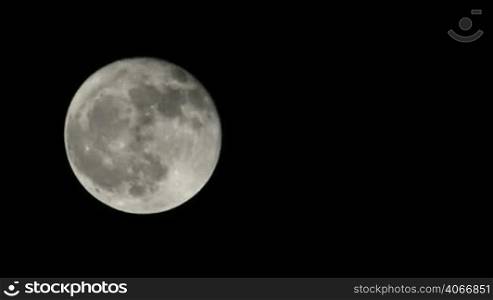 Scary Full Moon in a Cloudy Night. Very detailed lunar surface with its valleys and craters. Suitable for fear, scary and terror scenes. Awesome full moon. Night of wolf, Halloween night, nightmare.