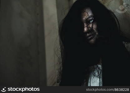 Scary ghost woman. Close up face of Asian woman ghost or zombie horror creepy scary have hair covering the face her eye at abandoned dark tone, female make up zombie broken face, Happy Halloween day