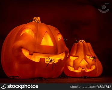 Scary glowing pumpkin with creepy spiders on dark red background, festive border, night of horror, Halloween party