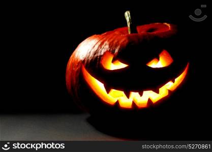 Scary smiling Halloween pumpkin on dark background. Halloween pumpkin on black