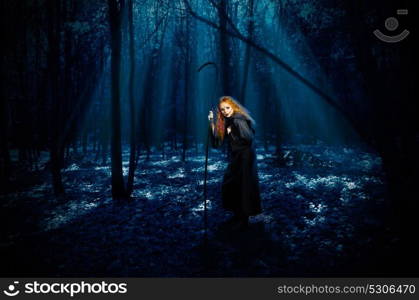 Scary witch in night forest