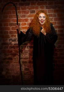 Scary witch on brick wall background