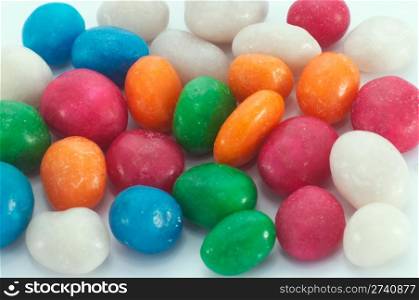scatter multicolored icing glaze sweeties on white