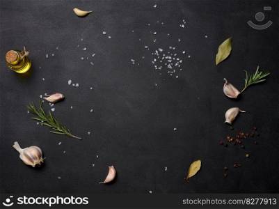 Scattered coarse white salt, peppercorns and rosemary sprigs on a black table, ingredients for cooking fish and meat. Copy space
