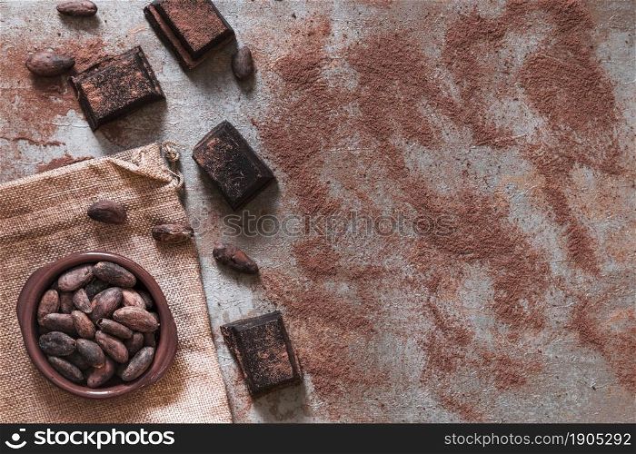 scattered cocoa powder with chocolate pieces cocoa beans bowl. Beautiful photo. scattered cocoa powder with chocolate pieces cocoa beans bowl