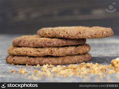 scattered on the wooden floor and sprinkling crumbs round-shaped oatmeal cookies during breakfast or dessert meal. crumbs round-shaped oatmeal cookies