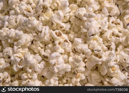 Scattered salted popcorn, food texture background. Fastfood popular during a movie in a cinema. Popcorn texture. Popcorns.