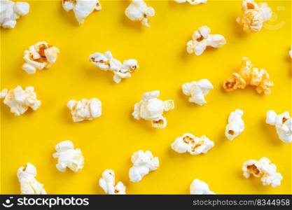 Scattered tasty cheese popcorn isolated on yellow background. Top view, flat lay , banner, wallpaper