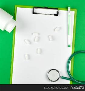 scattered white oval tablets from a plastic jar, medical background, top view