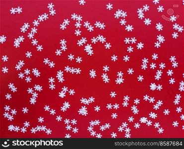 Scattered white snowflakes on red background. Simple festive flat lay. Stock photography.. Scattered white snowflakes on red background. Simple festive flat lay. Stock photo.