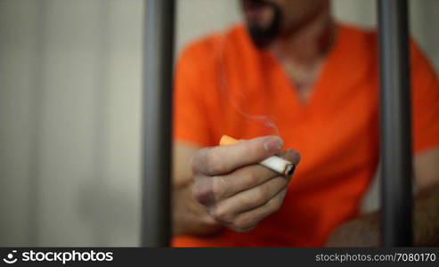 Scene of a depressed inmate smoking in prison