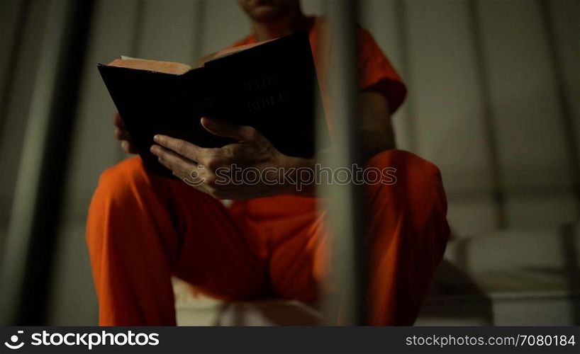 Scene of an inmate reading a bible in prison