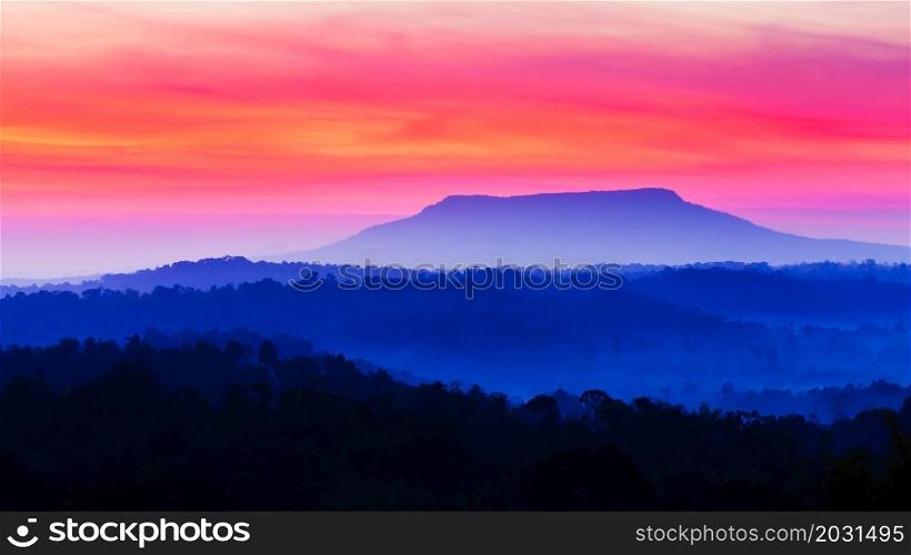 Scenery of blue mountains against colourful sunrise sky, abstract ripples clouds in the early light. Holiday, vacations concepts. Soft focus on the sky.