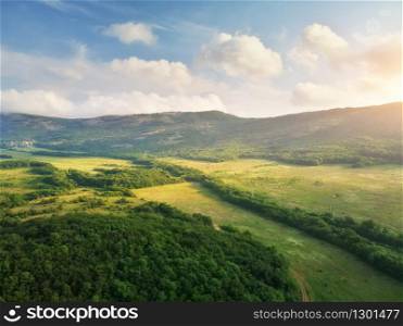 Scenic aerial view of beautiful landscape of the valley and hills in the background and dramatic clouds in the sky.