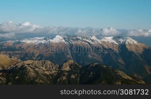 Scenic aerial view of mountains and clouds. Looking at beautiful landscape from flying airplane