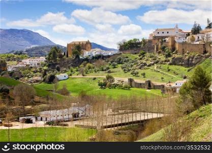 Scenic Andalusia landscape, old town of Ronda on a green hills, stud farm in a valley, southern Spain, Malaga province.