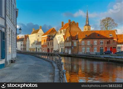 Scenic city view of Bruges canal with beautiful medieval houses and church, Belgium