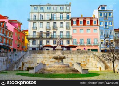 Scenic cityscape of Lisbon Old Town with traditional colorful tiled architecture, old fountain at small paved square, Portugal