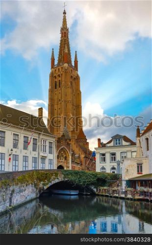Scenic cityscape with a medieval fairytale canal and the quay Dijver and Church of Our Lady in Bruges, Belgium