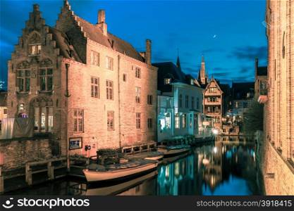 Scenic cityscape with the picturesque night medieval canal Dijver in Bruges, Belgium. Toning in cool tones