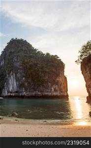 Scenic curve of tropical beach in morning light, sunrise shines through fantastic cliff on blue sea and white sand beach. Summer season. Koh Hong Island, Andaman sea, Krabi, Thailand. Summer season. Copy space.