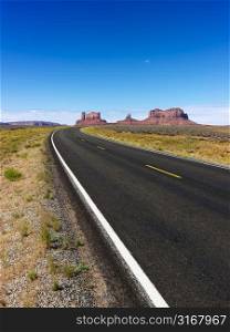 Scenic desert road with mountain land formations.