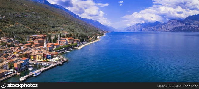 Scenic Lake Lago di Garda, Italy, aerial view of fishing village with colorful houses and boats - Castelletto di Brenzone. 