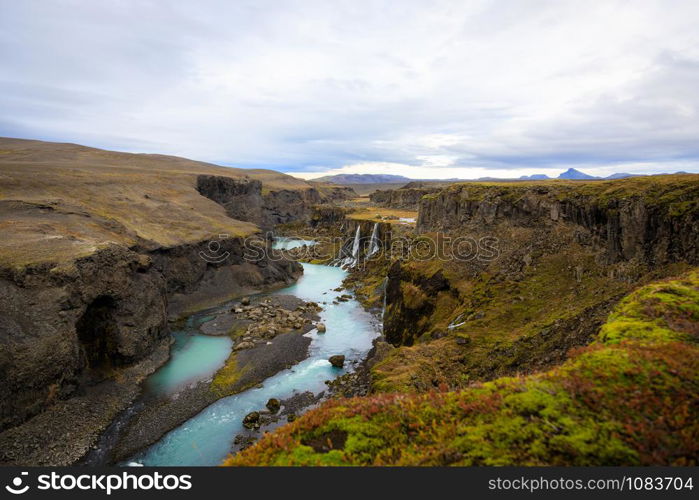 Scenic landscape view of incredible Sigoldugljufur canyon in highlands with turquoise river, Iceland. Volcanic landscape on background. Popular tourist attraction.