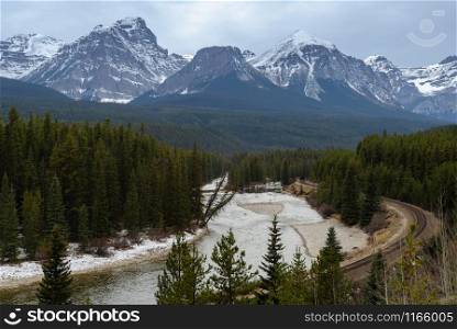 Scenic Morant?s Curve of Bow River and curved railroad track with snow-covered Mount temple background in Banff National Park, Alberta, Canada