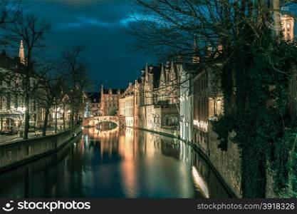 Scenic night cityscape with a medieval tower Belfort and the Green canal, Groenerei, in Bruges, Belgium. Toning in cool tones