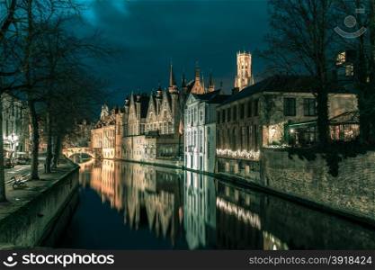 Scenic night cityscape with a medieval tower Belfort and the Green canal, Groenerei, in Bruges, Belgium. Toning in cool tones