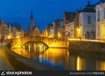 Scenic night cityscape with views of Spiegelrei, Canal Spiegel, bridge and church in Bruges, Belgium