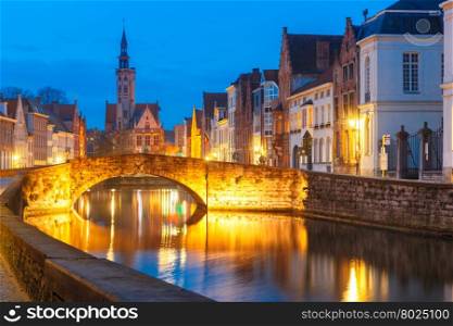 Scenic night cityscape with views of Spiegelrei, Canal Spiegel, bridge and church in Bruges, Belgium