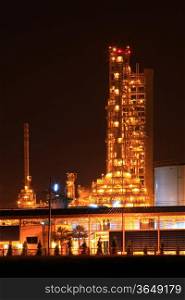 scenic of petrochemical oil refinery plant shines at night, vertical closeup
