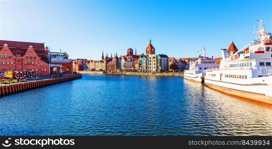 Scenic panorama of the Old Town pier architecture of Gdansk, Poland at the Motlawa River harbor embankment with medieval port and historical ships