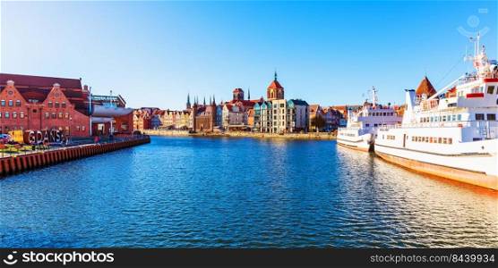 Scenic panorama of the Old Town pier architecture of Gdansk, Poland at the Motlawa River harbor embankment with medieval port and historical ships