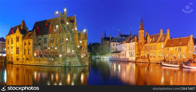 Scenic panorama with medieval fairytale town and tower Belfort from the quay Rosary, Rozenhoedkaai, at night, Bruges, Belgium