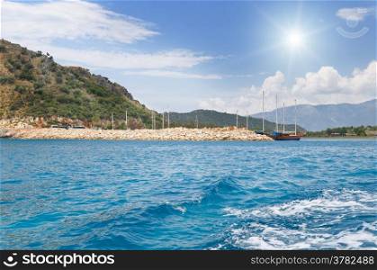 scenic seascape, blue sky, sun, yacht