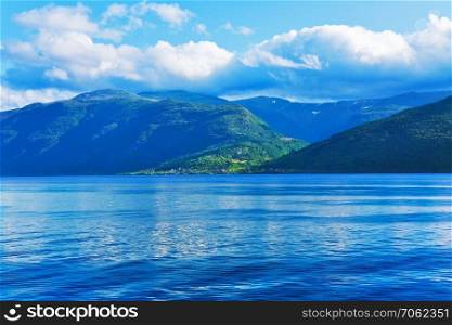 Scenic summer landscape of Sognefjord fjord in Norway, Scandinavia with high mountains, sea water and blue sky with clouds