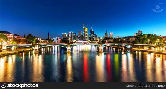 Scenic summer night panorama of the business corporate downtown bank district with high tall skyscraper buildings and illuminated bridge over the Main River in Frankfurt am Main, Germany