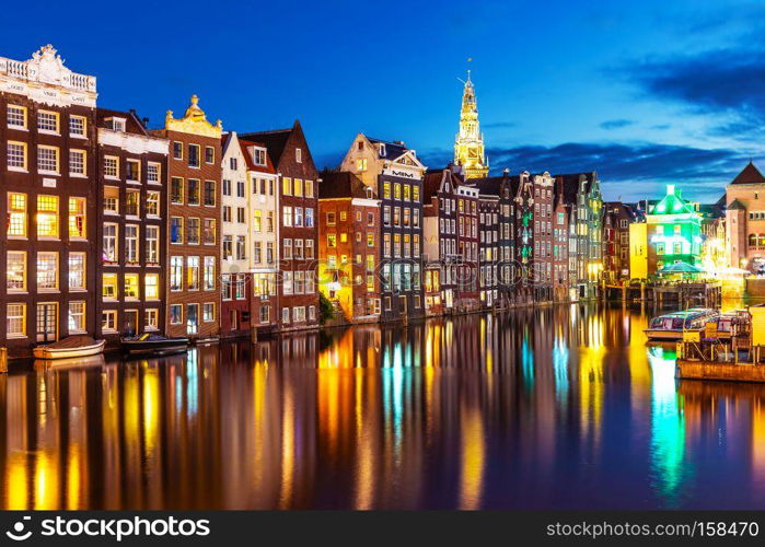 Scenic summer night view of iconic ancient medieval buildings in the Old Town of Amsterdam, Netherlands