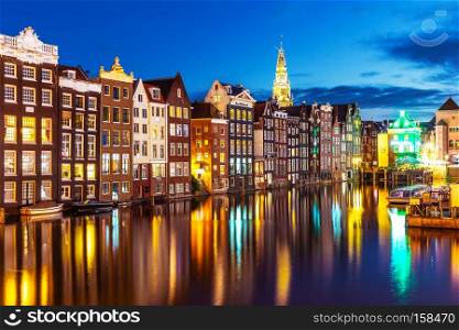 Scenic summer night view of iconic ancient medieval buildings in the Old Town of Amsterdam, Netherlands