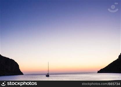 Scenic sunrise or sunset over sea surface, yacht boat anchored in bay, Greece. Sunrise or sunset over sea surface