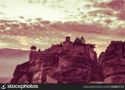 Scenic sunset evening sky over holy Varlaam monastery on cliff in Meteora, Thessaly Greece. Greek destinations. Sunset over Varlaam monastery in Meteora, Greece