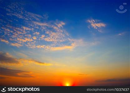 Scenic sunset on background bright blue sky and orange clouds